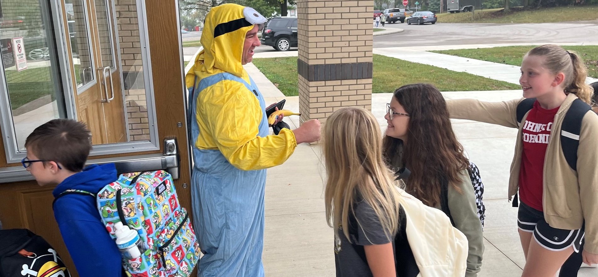 Principal dressed as a &#34;Minion&#34; Disney character greets arrive students for special Walk-A-Thon Day