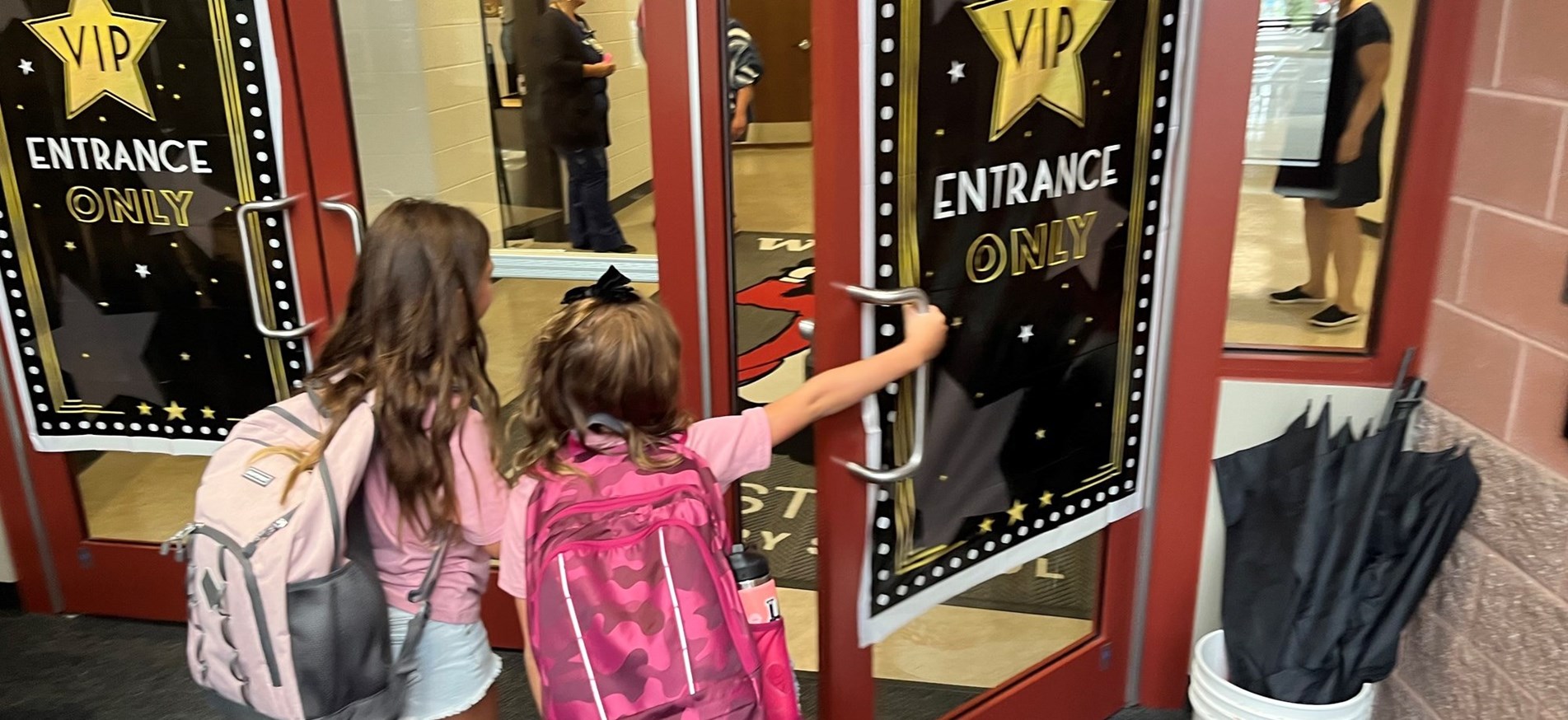 Students enter through elementary school door on first day of 2023-24 school year