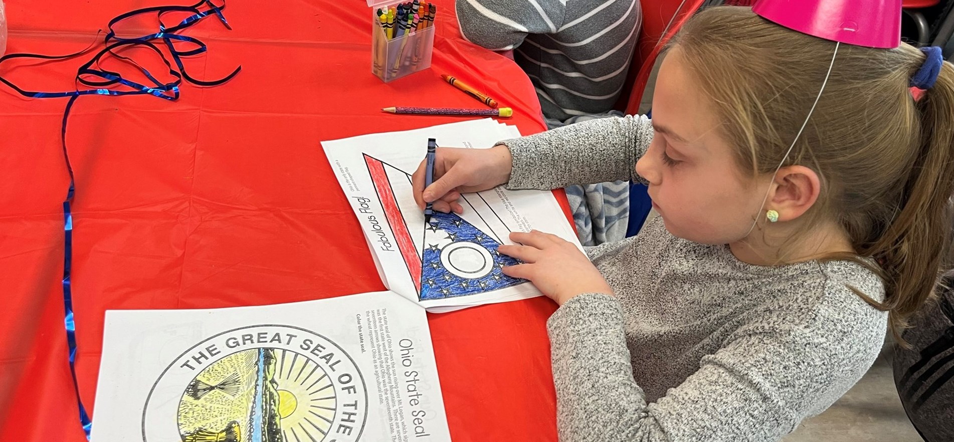 Student coloring Ohio Flag and Great Seal to mark anniversary of Ohio statehood.