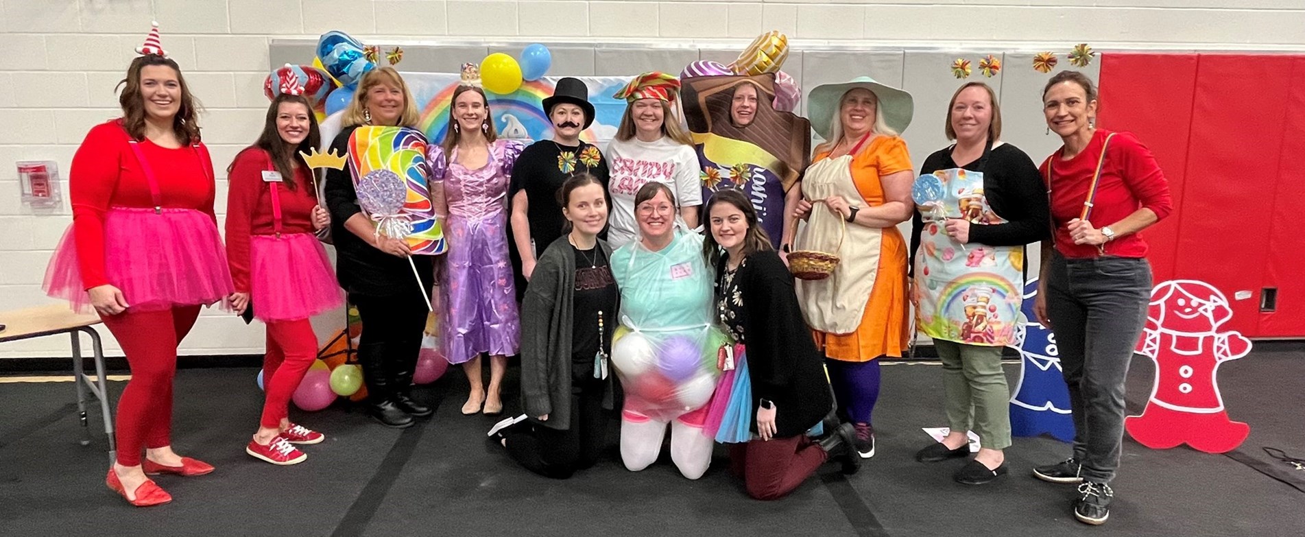 Teachers dressed in Candyland Game Costumes line up in gym.